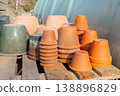Clay terracotta pots arranged near a greenhouse. 138896829