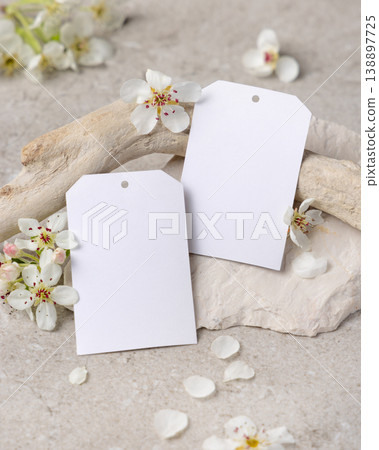Blank vertical gift tags mockup with white spring flowers and driftwood on light stone, product tag 138897725