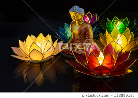 Vesak day. Buddha meditating with colorful floating lotus lantern candles Vesak day. Buddha meditating with colorful floating lotus lantern candles 138899185