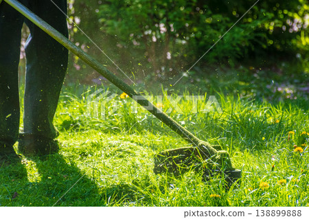 professional garden service at work. lawn care concept. cutting an mowing grass in the park. spring summer season. backlit gardening scene. grass ground view for design 138899888