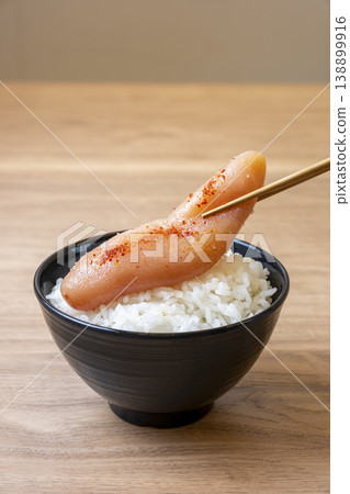 A bowl of rice topped with a whole piece of mentaiko (spicy cod roe). A bowl of rice topped with a whole piece of mentaiko (spicy cod roe). 138899916
