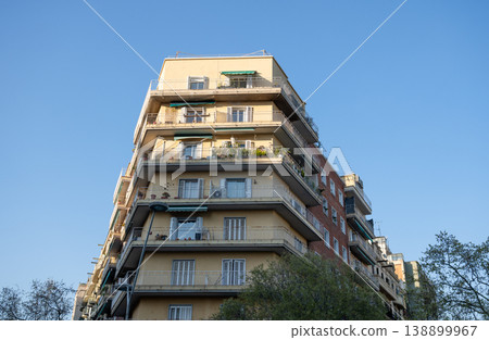 Corner residential apartment building with balconies under clear blue sky in Barcelona Spain 138899967