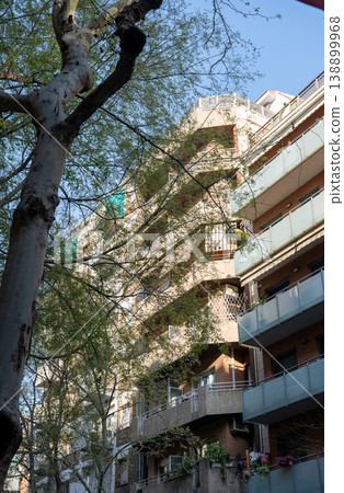 Residential apartment building with balconies and trees in sunny street in Barcelona Spain 138899968