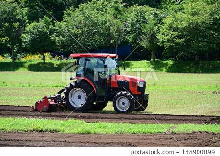 Under the blue sky, farming work in the field, tilling the soil. 138900099