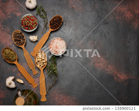 Various culinary spices in wooden spoons on brown background, top view 138900121