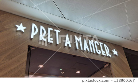 London UK - 07.01.2025 Pret A Manger storefront with illuminated sign on a wooden wall, representing a popular food chain known for organic coffee, sandwiches, and freshly prepared healthy meals London UK - 07.01.2025 Pret A Manger storefront with illuminated sign on a wooden wall, representing a popular food chain known for organic coffee, sandwiches, and freshly prepared healthy meals 138900167