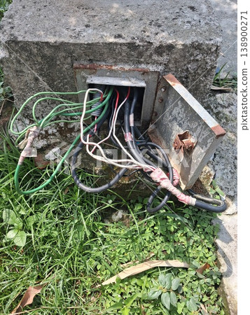 Exposed Electrical Cables and Wires in Rusty Outdoor Utility Box on Concrete Base Exposed Electrical Cables and Wires in Rusty Outdoor Utility Box on Concrete Base 138900271