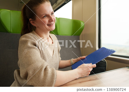 Woman organizing bag and belongings during train trip Woman organizing bag and belongings during train trip 138900724