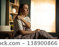 Woman sitting in bed, holding her painful shoulder, expressing discomfort and stiffness after waking up, showing musculoskeletal aches and health problems 138900866