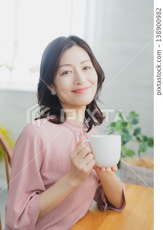 Middle-aged woman holding a mug 138900982