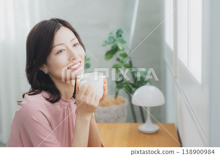 拿著杯子的中年婦女 拿著杯子的中年婦女 138900984