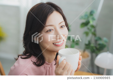 拿著杯子的中年婦女 拿著杯子的中年婦女 138900985