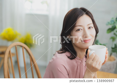 拿著杯子的中年婦女 拿著杯子的中年婦女 138900987