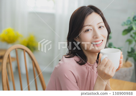 拿著杯子的中年婦女 拿著杯子的中年婦女 138900988