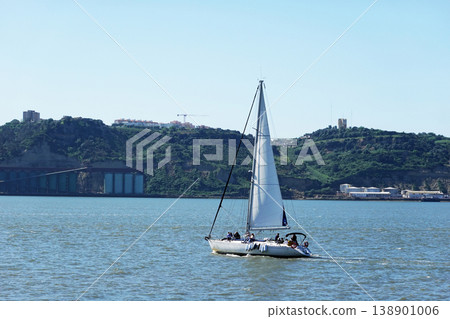 Sailing Yacht on Calm Water with Green Hills in Background 138901006