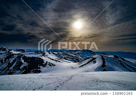 北海道的冬天：月光與雲朵交相輝映，白雪皚皚的山脈在夜空中交相輝映，構成了一幅壯麗的景象。這幅景象展現了北海道雄偉的自然風光。皚皚雪峰在冬日的夜空中熠熠生輝，令人嘆為觀止。 138901165