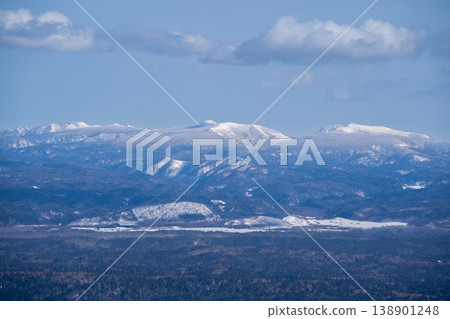 Hokkaido in winter: Snow-covered mountain ranges clad in forest. Hokkaido's forest landscape, woven from birch and coniferous trees. The deep Hokkaido landscape, woven from birch and coniferous trees. Hokkaido in winter: Snow-covered mountain ranges clad in forest. Hokkaido's forest landscape, woven from birch and coniferous trees. The deep Hokkaido landscape, woven from birch and coniferous trees. 138901248