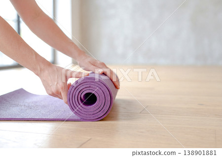 特寫鏡頭：雙手捲起瑜珈墊 138901881
