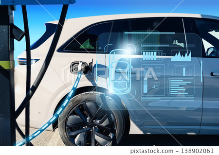 Charging an electric car at a station in bright daylight while checking the battery status Charging an electric car at a station in bright daylight while checking the battery status 138902061