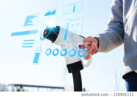 Electric car charging process shows user interacting with charger in outdoor location Electric car charging process shows user interacting with charger in outdoor location 138902111