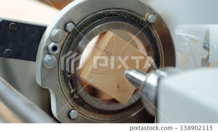 Wood block being shaped on a lathe in a workshop during the day Wood block being shaped on a lathe in a workshop during the day 138902115