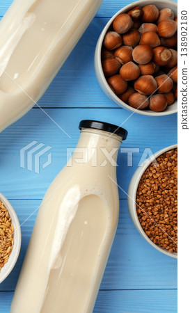 Hazelnut milk with nuts and grains on blue wooden table Hazelnut milk with nuts and grains on blue wooden table 138902180
