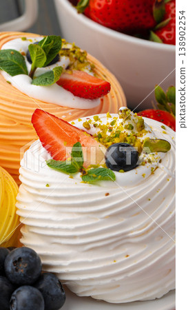 Delicious desserts with fruits and cream at a dessert table in a bright kitchen setting Delicious desserts with fruits and cream at a dessert table in a bright kitchen setting 138902254