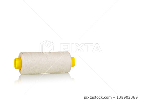 skein of beige color thread macro on a white background 138902369
