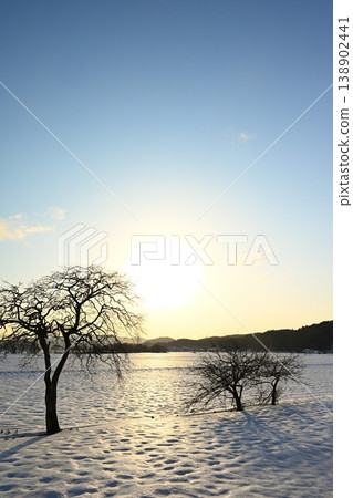 Snow-covered land silhouetted against the setting sun (Inawashiro Town, Fukushima Prefecture) 138902441