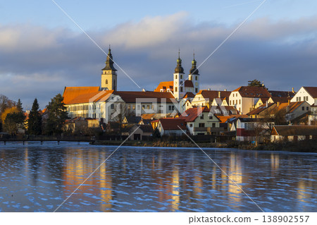 Telc cityscape reflecting on a frozen lake at sunset Telc cityscape reflecting on a frozen lake at sunset 138902557