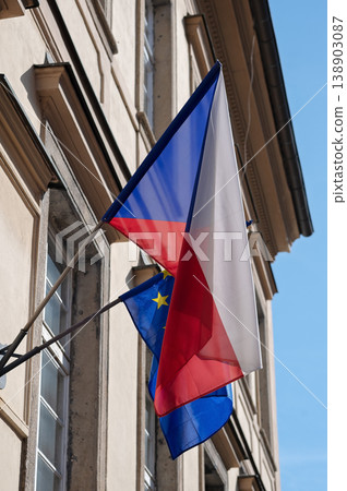 Czech Republic and European Union flags waving on building exterior against clear blue sky Czech Republic and European Union flags waving on building exterior against clear blue sky 138903087