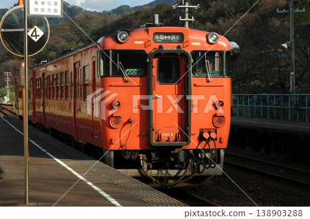 一輛朱紅色的Kiha 47系列柴油動車組(日本國鐵塗裝)停靠在山陰本線的一個月台上。 一輛朱紅色的Kiha 47系列柴油動車組(日本國鐵塗裝)停靠在山陰本線的一個月台上。 138903288