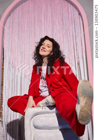 Graceful woman in vibrant red attire extending welcoming gesture Graceful woman in vibrant red attire extending welcoming gesture 138903475