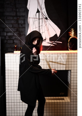 Shadowed figure standing alert near vibrant mural inside urban decay 138903541