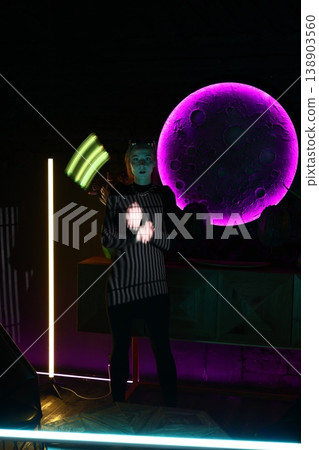 Street character hidden in neonlit urban setting at night 138903560