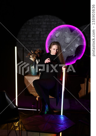 Subject appears pensive amid vibrant violet illuminated setting 138903636