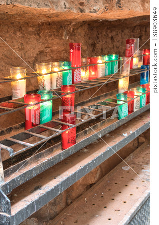 Rows of colorful votive candles are lit in a sacred space at Montserrat, a mountain monastery near Barcelona Rows of colorful votive candles are lit in a sacred space at Montserrat, a mountain monastery near Barcelona 138903649