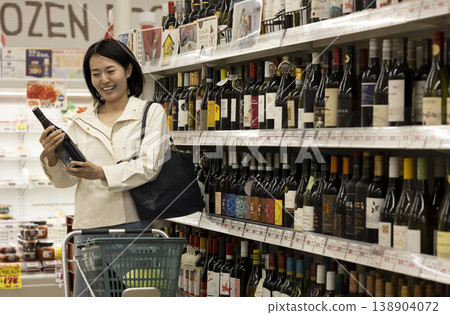 A woman choosing wine at the supermarket A woman choosing wine at the supermarket 138904072