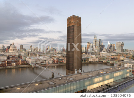 This sweeping vista captures London in a moment of twilight serenity, dominated by the brutalist grandeur of the Tate Modern iconic brick chimney. Standing as a bold, monolithic anchor in the center This sweeping vista captures London in a moment of twilight serenity, dominated by the brutalist grandeur of the Tate Modern iconic brick chimney. Standing as a bold, monolithic anchor in the center 138904076