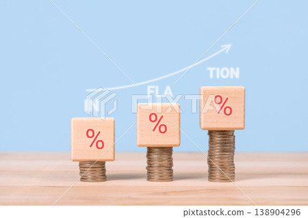 Wooden block stacks of coins pointing up and the word inflation on a blue background. Increase in interest rates. Global economy, bankruptcy and controlling inflation. 138904296
