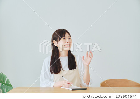A woman is taking notes on the menu; a scene depicting meal preparation and daily planning. A woman is taking notes on the menu; a scene depicting meal preparation and daily planning. 138904674