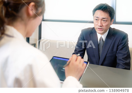 A businessman with a serious expression undergoing an interview. A businessman with a serious expression undergoing an interview. 138904978