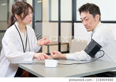 一位男性商務人士正在測量血壓。 一位男性商務人士正在測量血壓。 138904980