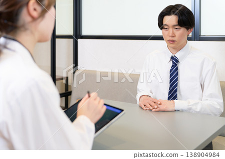 A young male employee receives counseling at work. A young male employee receives counseling at work. 138904984