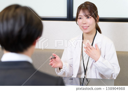A medical professional in a white coat conducting an interview during a mental health care consultation. 138904988