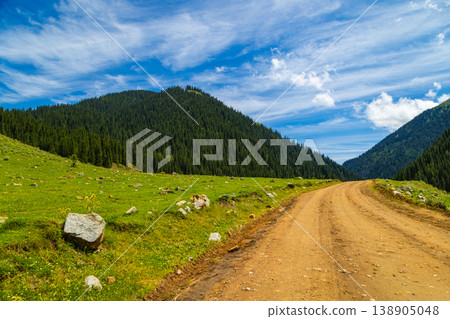 Dirt road through serene mountain valley in Kyrgyzstan Dirt road through serene mountain valley in Kyrgyzstan 138905048
