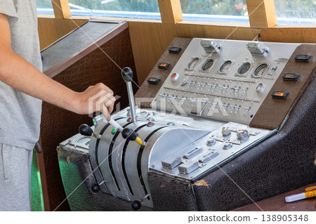Adult man operating control panel in ship cabin Adult man operating control panel in ship cabin 138905348