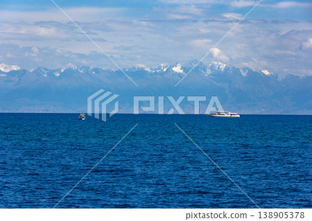 Two boats on serene lake with mountains in background 138905378
