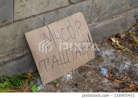 Cardboard sign indicating food waste on urban street written in Kyrgyz meaning dont litter. Cardboard sign indicating food waste on urban street written in Kyrgyz meaning dont litter. 138905451