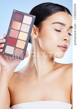 Beauty, eyeshadow and woman with makeup on blue background for cosmetics, powder and foundation. Cosmetology, salon aesthetic and face of girl with palette, facial glow and luxury products in studio Beauty, eyeshadow and woman with makeup on blue background for cosmetics, powder and foundation. Cosmetology, salon aesthetic and face of girl with palette, facial glow and luxury products in studio 138905844